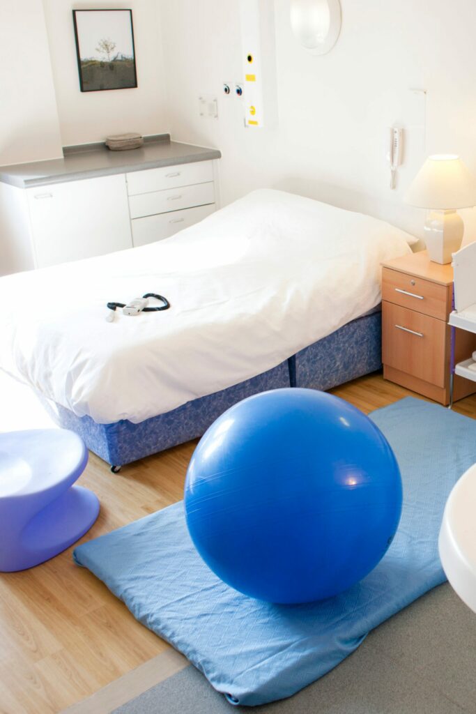A bedroom with a bed and a blue ball on the floor