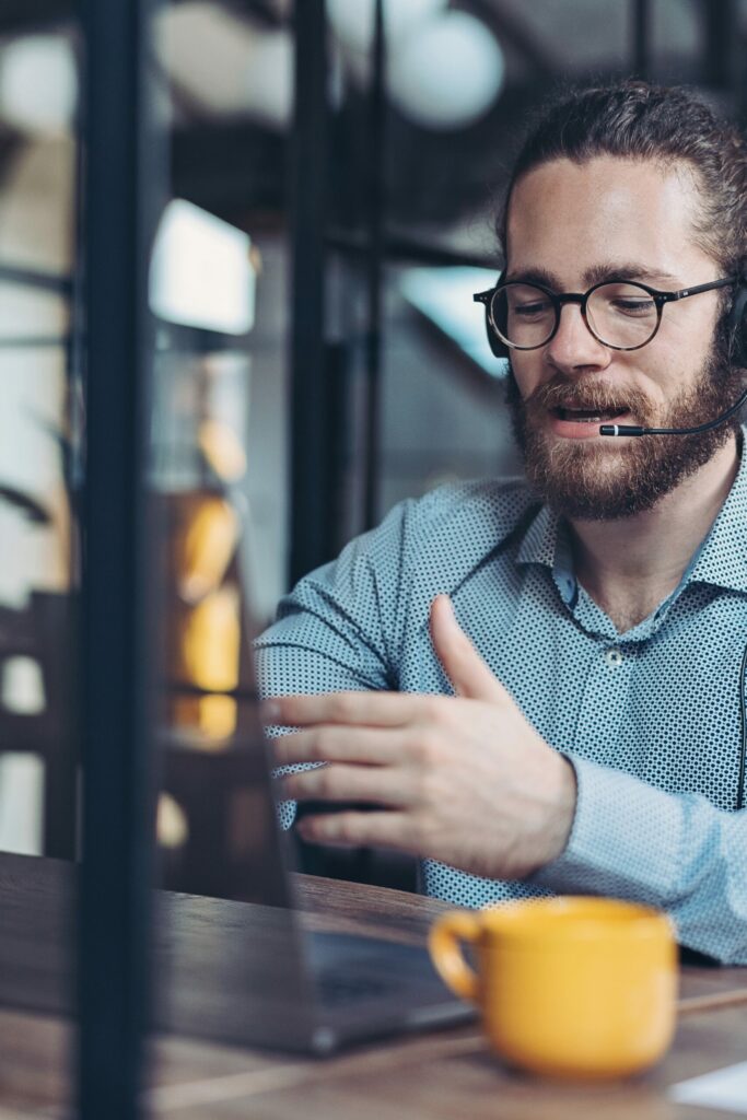 A man wearing a headset sitting at a table